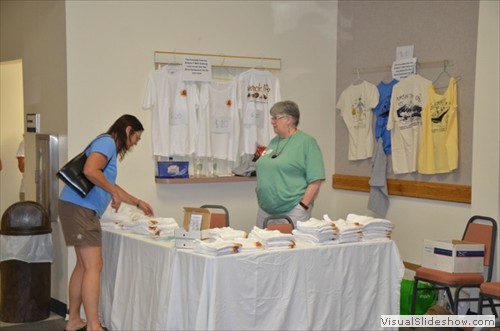 Sam Burnett (green shirt) selling T-shirts etc.